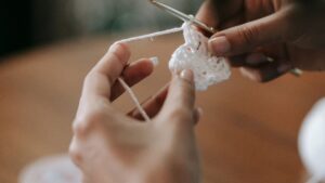 A Person Holding a Crochet Hook and Yarn