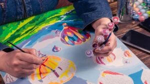 A Person's Hands Painting Hot Air Balloons