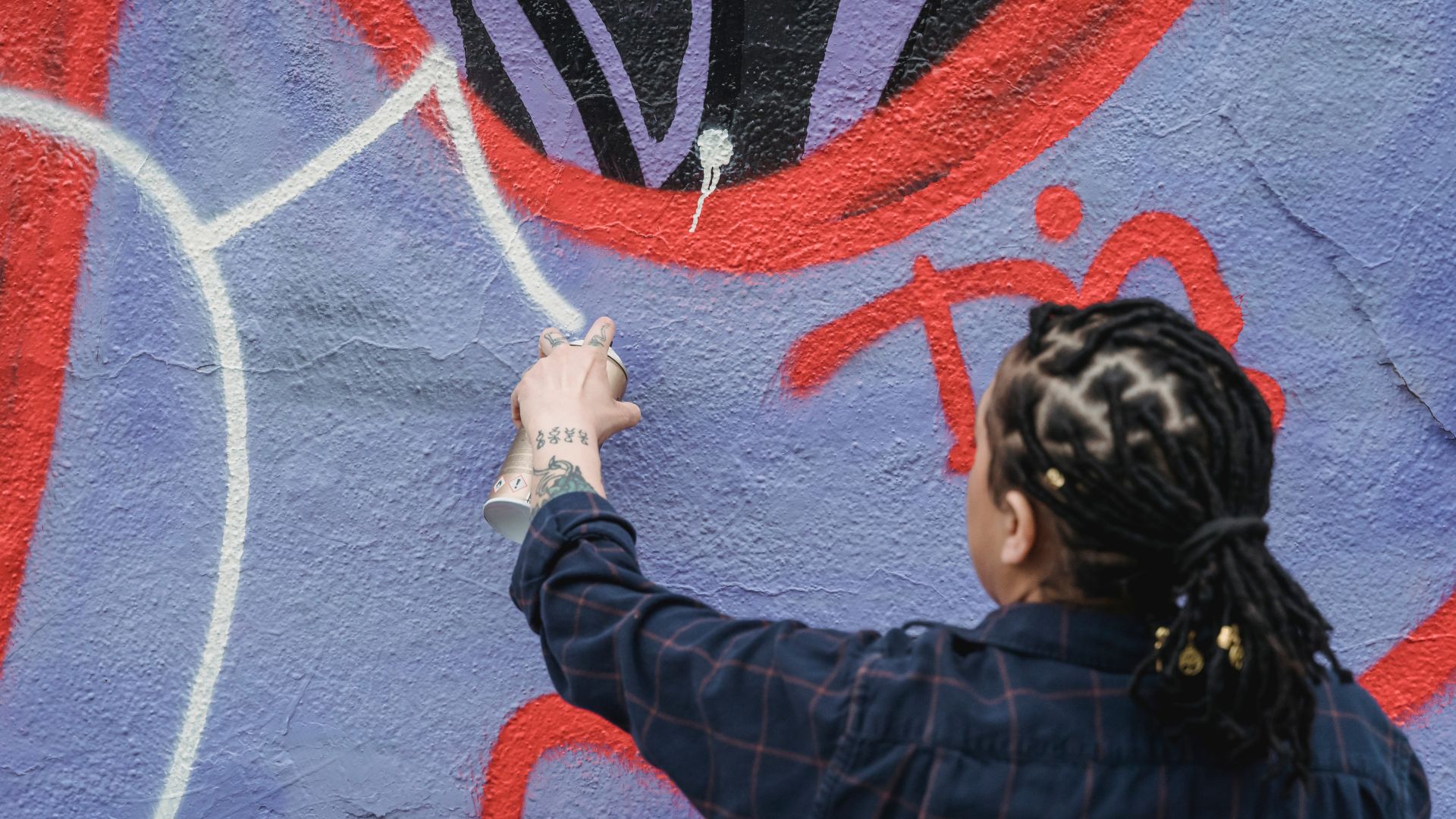 Anonymous woman painting graffiti with paint