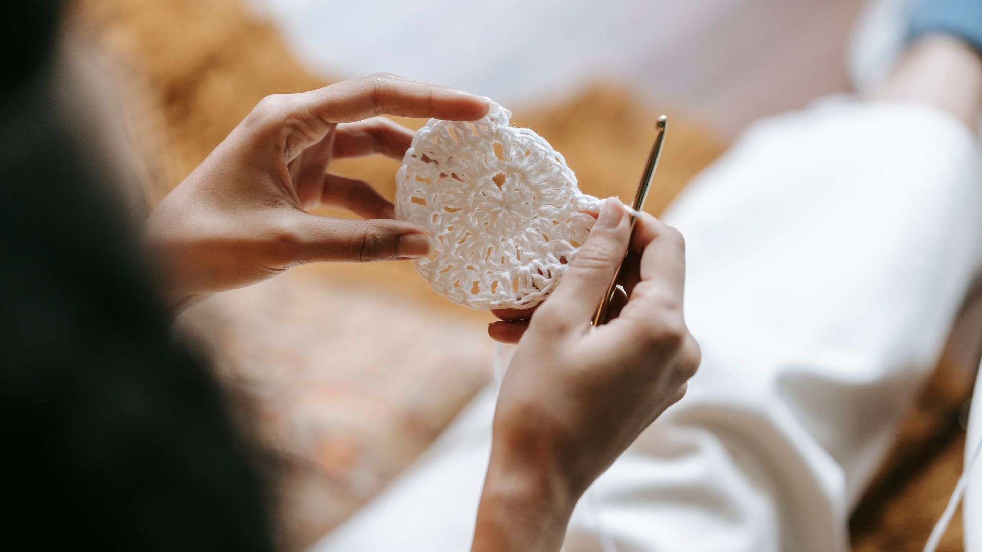 Crop craftswoman with hook and crocheted textile at home