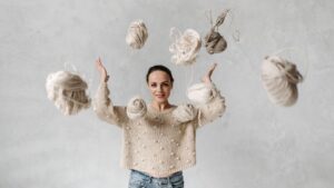 Girl in White Sweater Throwing Yarn Balls