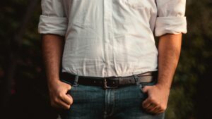 Man in White Dress Shirt and Blue Denim Jeans Standing Near Green Trees