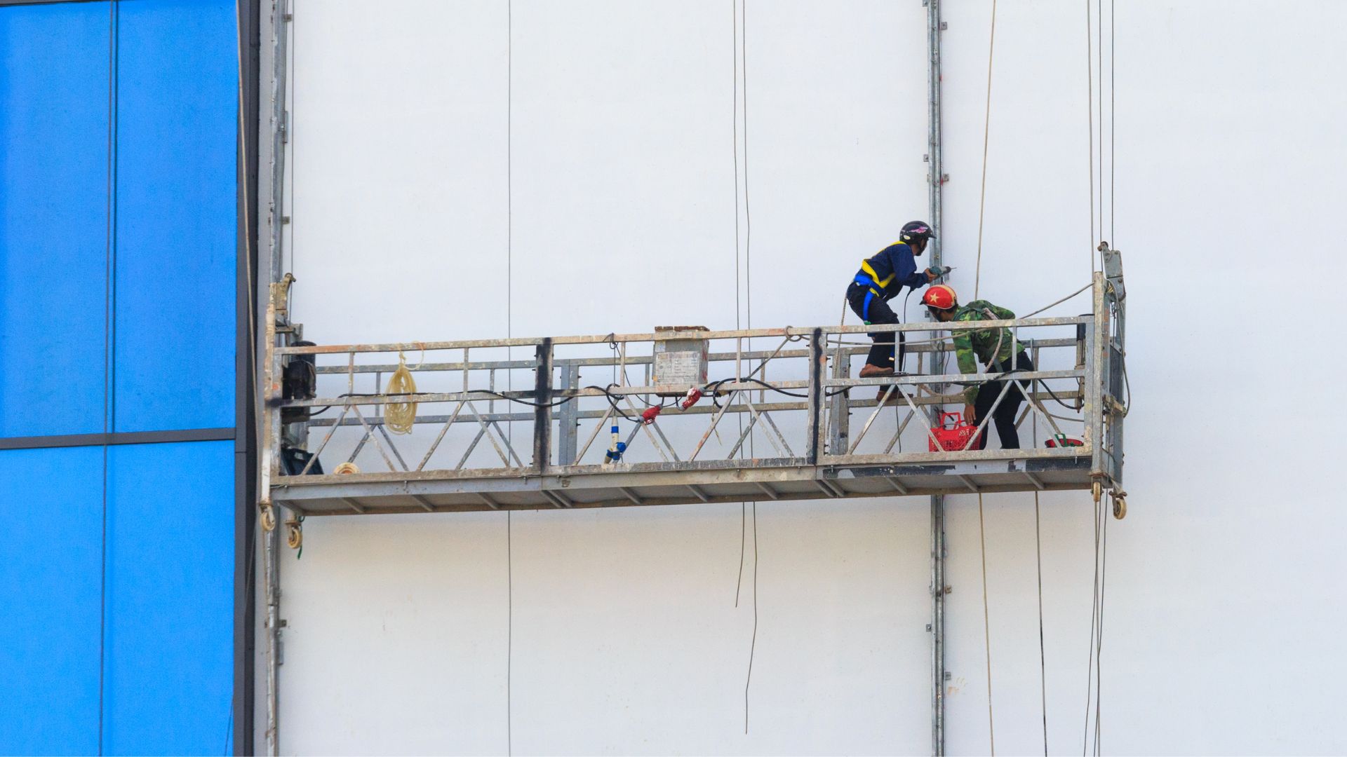 Men Working on Scaffolding near Advertisement Board on Building