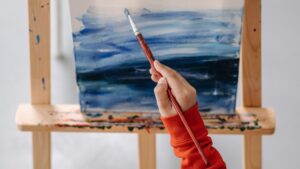 Overhead Shot of a Person in Orange Long Sleeve Painting