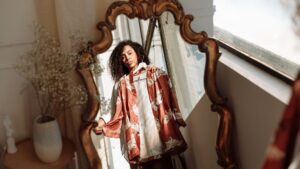 Reflection of a Woman Holding a Hanger with a Shirt