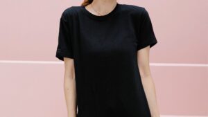 Smiling model in black t shirt against staircase