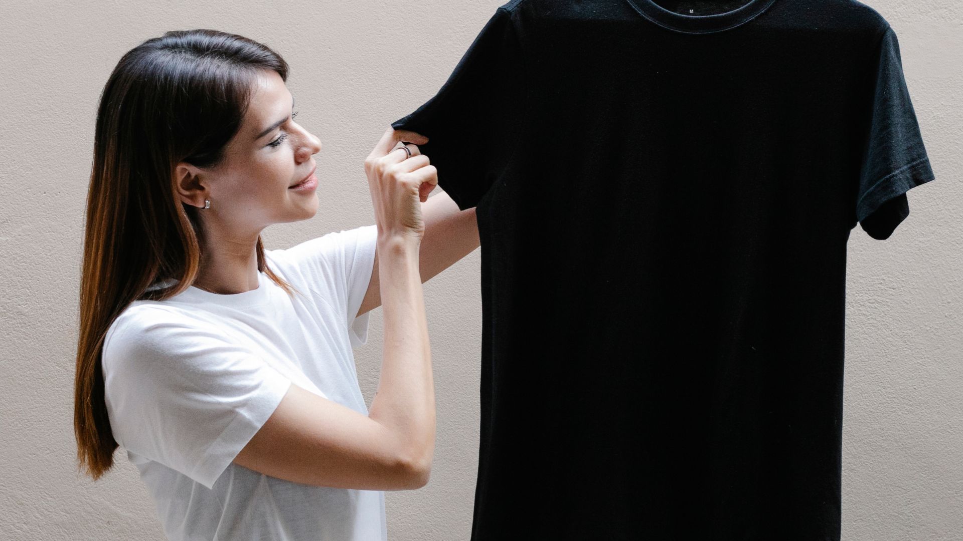 Smiling woman showing t shirt on hanger