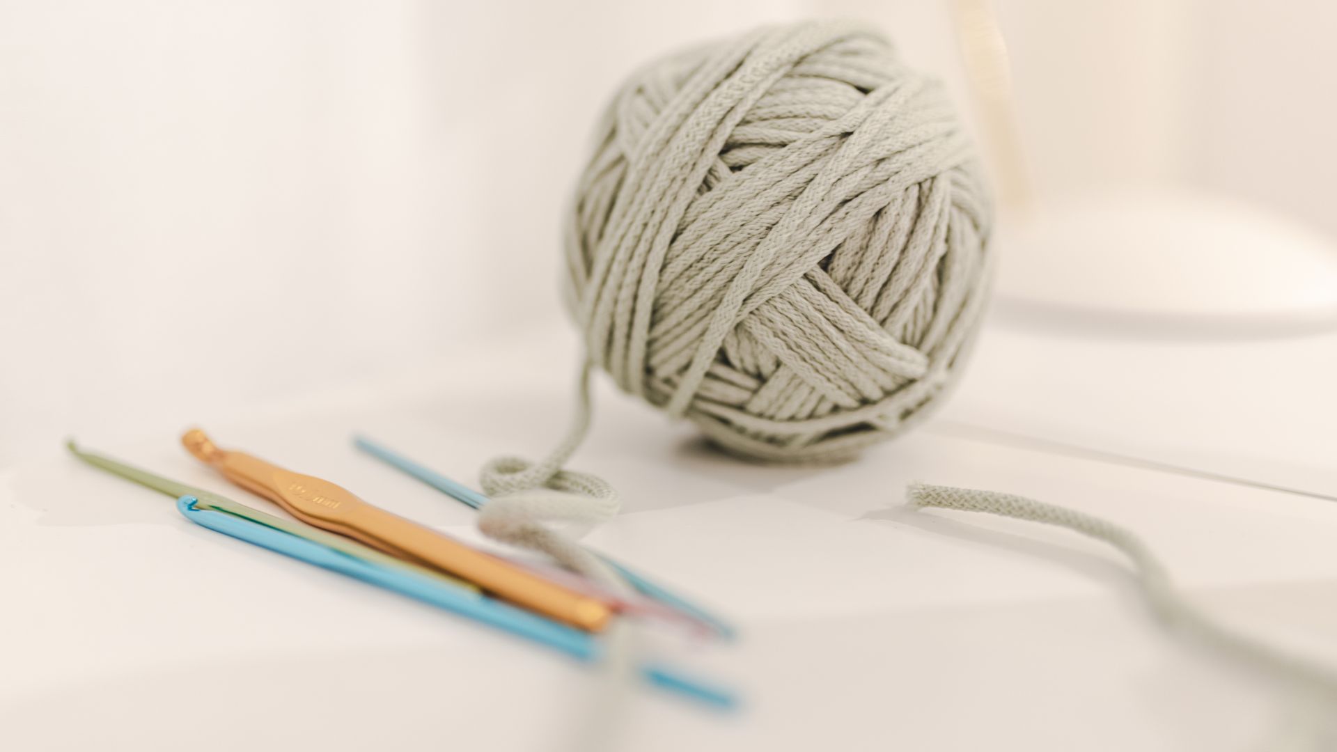 Threads for knitting arranged with crochets on table