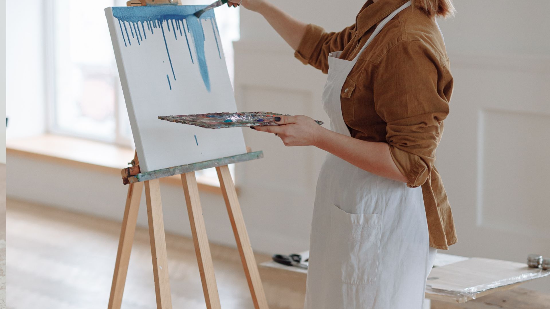 Woman in Brown Long Sleeves Painting on a Canvas