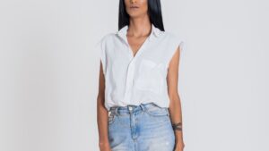 Woman in White Sleeveless Shirt and Denim Jeans Looking Away