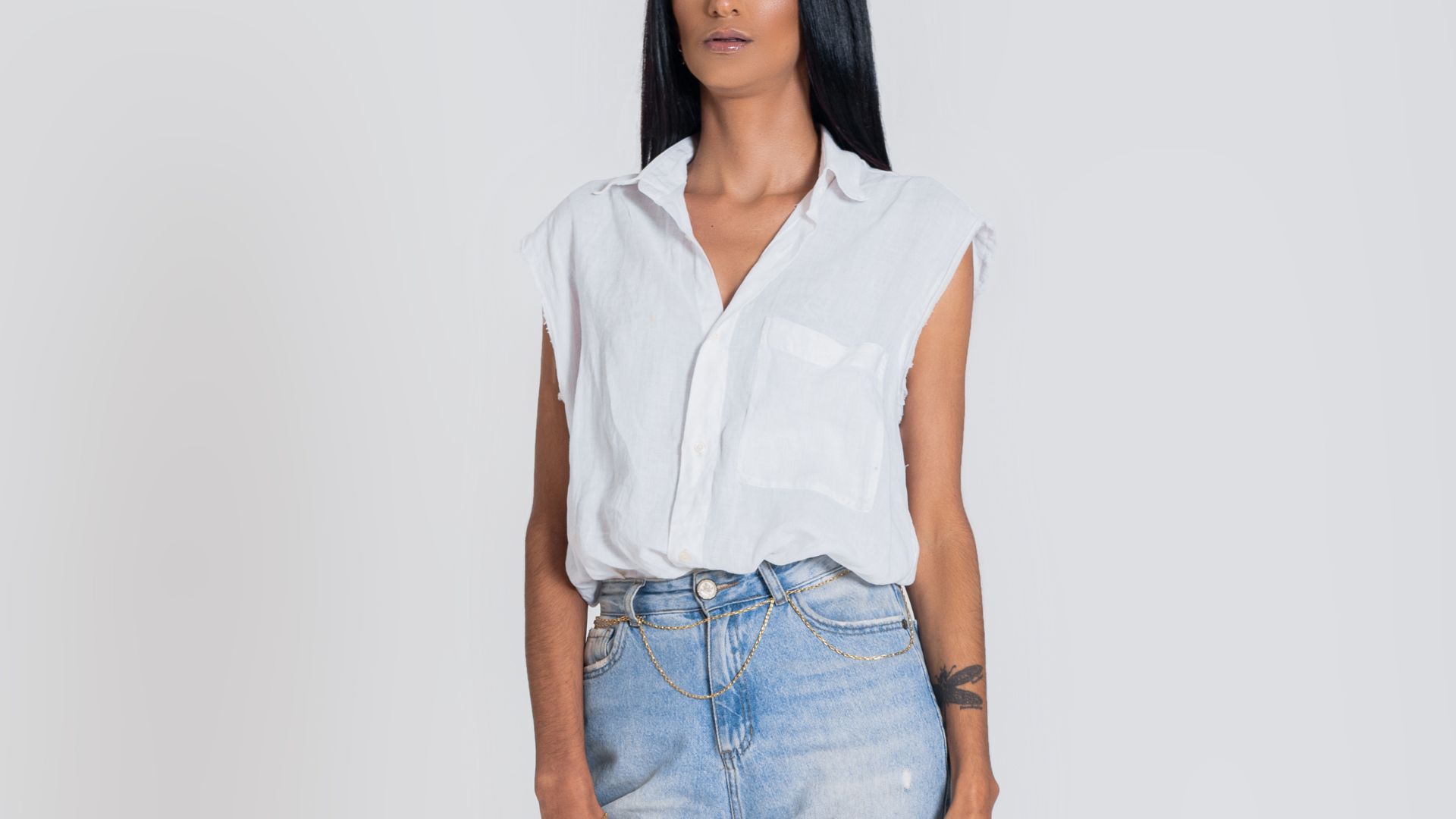 Woman in White Sleeveless Shirt and Denim Jeans Looking Away